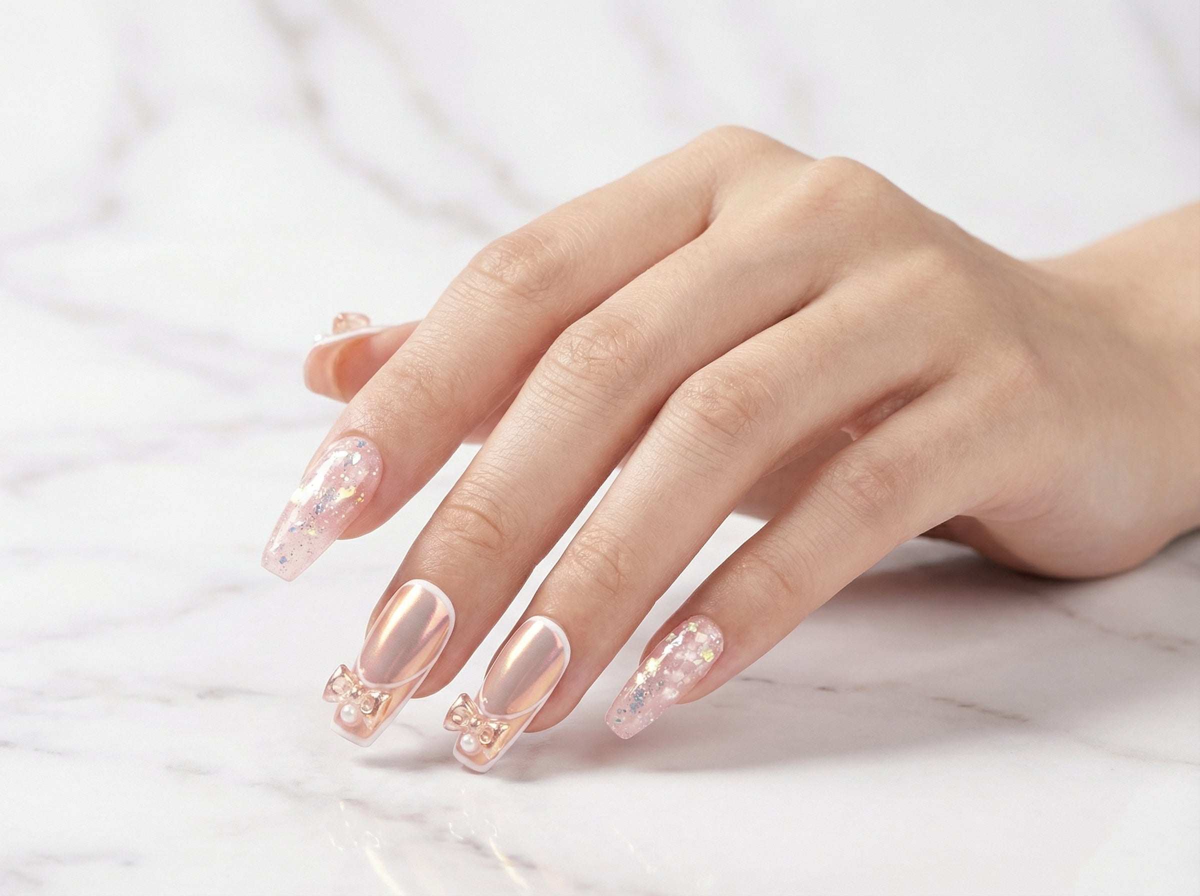 Close-up of pink chrome coffin nails showing gold foil detail
