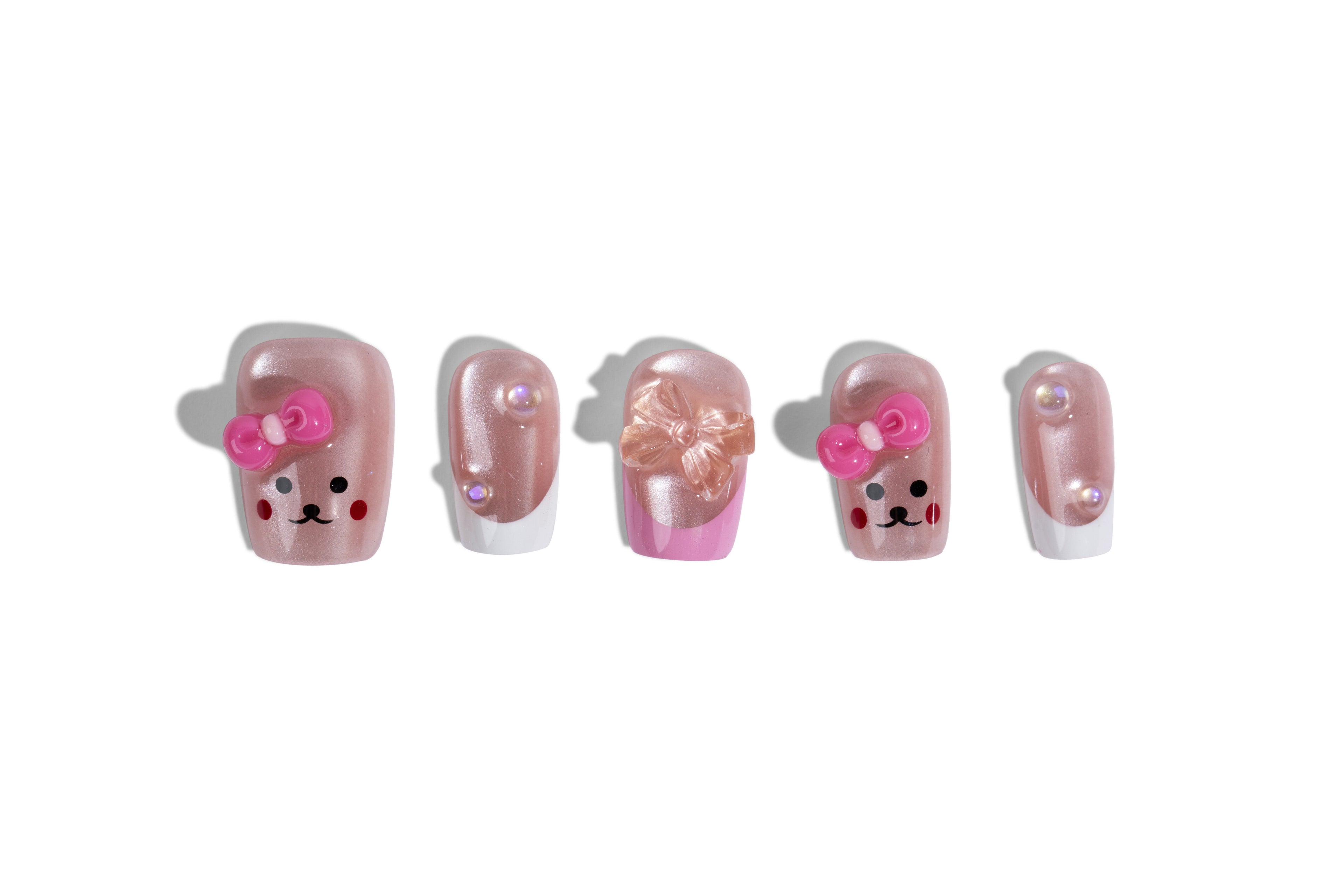 Pink bear press-on nails - five nails flat-laid on a white background showing the bear-face and bow design